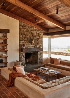 a living room filled with furniture and a fire place in front of a stone fireplace