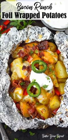 bacon ranch foil wrapped potatoes with sour cream and green peppers in the middle on top