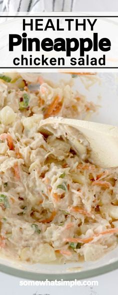 healthy pineapple chicken salad in a glass bowl with a wooden spoon on the side