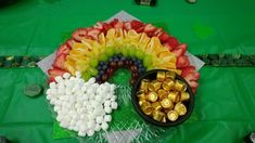 a table topped with lots of fruit and candy next to a bowl of candies