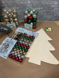 christmas ornaments are sitting on a table next to a cut out tree