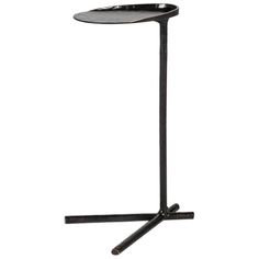 a black metal table with two legs and a tray on the top that is holding an object