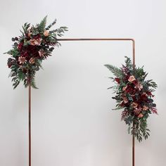 two metal frames with flowers and greenery on them