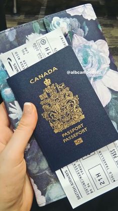 a person holding a canadian passport in front of a flowered background with the word canada on it