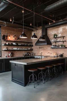 an industrial style kitchen with brick walls and black counters, bar stools, and hanging lights