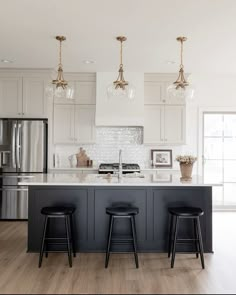 a kitchen with three stools next to an island