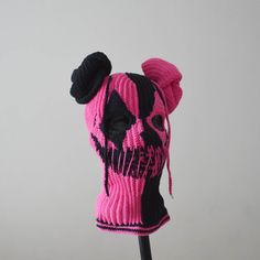 a pink and black knitted skull hat