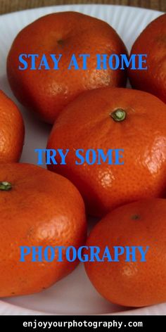 six oranges sitting on top of a white plate with the words stay at home try some photography