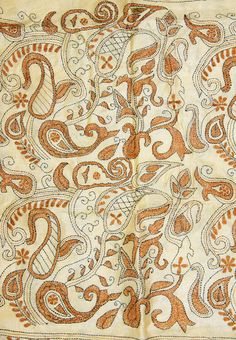 an orange and white paisley design on a piece of cloth