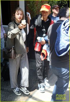 two people standing next to each other holding donuts