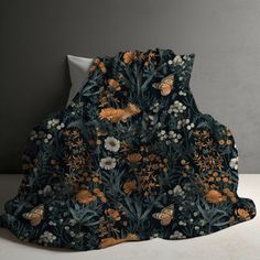 an image of a blanket with flowers and butterflies on the front, sitting on a table