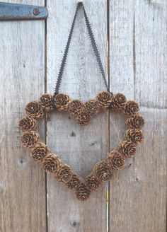 a heart made out of pine cones hanging on a door with an instagramr