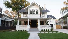 a white house with black roof and front porch