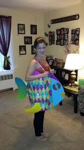 a woman holding a fish shaped kite in her living room