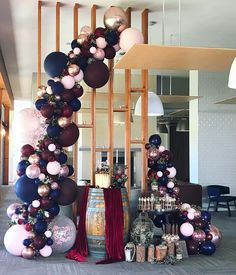 balloons are hanging from the ceiling in front of a wine barrel and other items on display