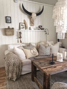 a living room filled with lots of white furniture and animal print pillows on the couch