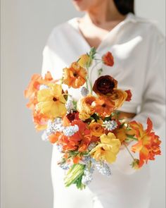 a woman holding a bouquet of flowers in her hands