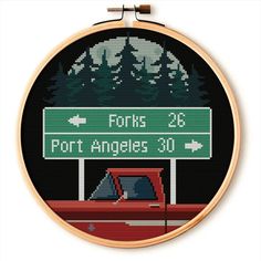 a cross stitch pattern with a red truck under a street sign that says forks 25 port angeles