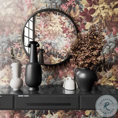 vases and mirrors on a shelf in front of a floral wallpaper