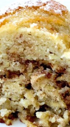 a close up of a piece of cake on a plate with powdered sugar and crumbs