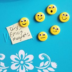 five yellow smiley face magnets sitting on top of a blue table next to a note that says diy emo magnets