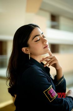 a woman with her chin resting on her hand and looking up at something in the air