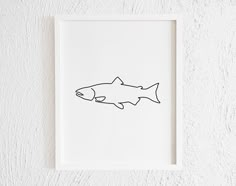 a black and white drawing of a fish in a frame on the wall above it