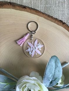 a keychain with the word mom on it and a flower in front of it