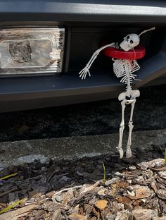 a skeleton standing in front of a car