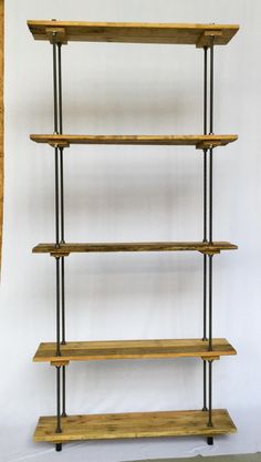 three wooden shelves with metal rods on each shelf, against a white wall in an empty room