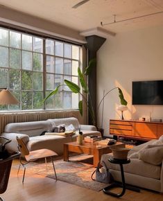 a living room filled with furniture and large windows