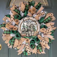 a green and brown wreath with the words welcome to moose on it's front door