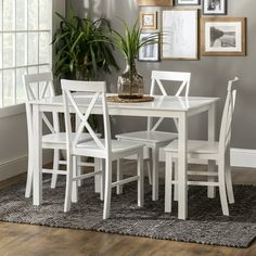 a white table and chairs in a room with pictures on the wall behind it,