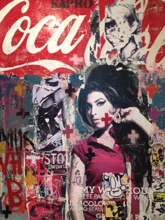 a woman standing in front of a wall covered in graffiti and coca - cola signs