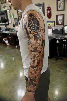 a man with a tattoo on his arm in a room full of pictures and paintings