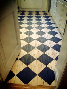 a black and white checkered tile floor in a kitchen with an open door leading to another room