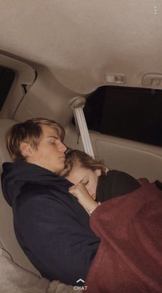 a man and child sleeping in the back seat of a car