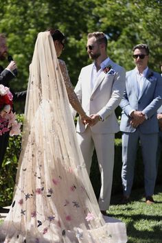 the bride and groom hold hands as they walk down the aisle