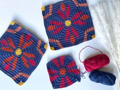 three crocheted squares and two balls of yarn on a white surface with a red ball of thread