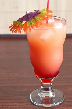 a drink in a glass with a straw garnish on the top and an orange flower sticking out of it