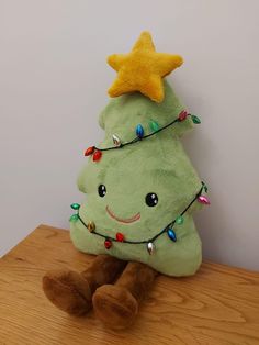 a stuffed christmas tree sitting on top of a wooden table