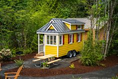 a tiny yellow house with red shutters on the windows