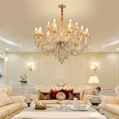 a fancy living room with chandelier, couches and coffee table in it