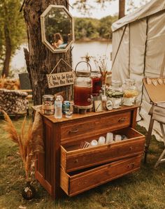 an old dresser with jars on it in front of a tree and the words, there are