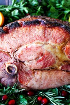 a large piece of meat sitting on top of a table next to oranges and greens