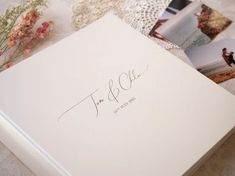 the wedding album is laying on top of the lace tablecloth with flowers and photos