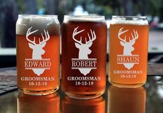 three beer glasses sitting on top of a table next to each other with deer heads