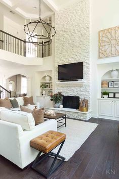 a living room filled with furniture and a flat screen tv mounted on the wall above a fireplace