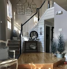 a living room filled with furniture next to a stair case covered in christmas tree ornaments