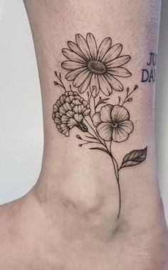 a black and white flower tattoo on the ankle